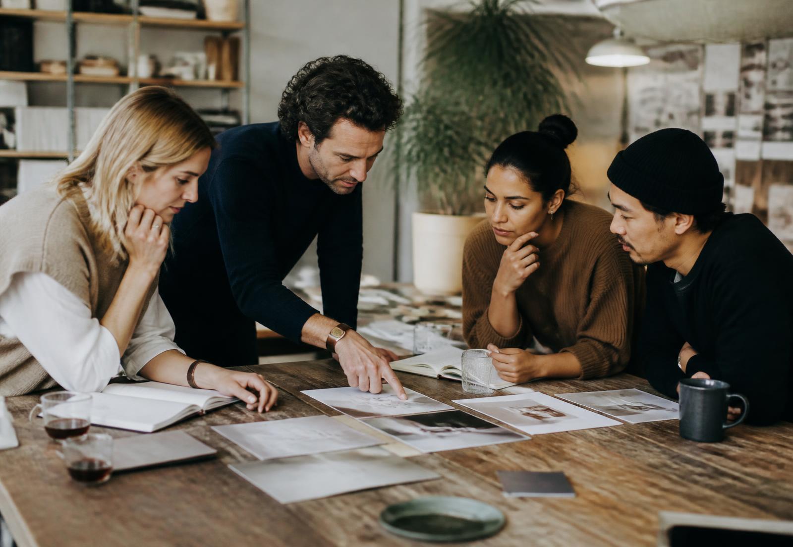 A creative team collaborating closely around a studio table